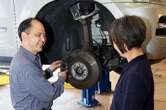 Ben from Hong Kong Auto Service shows customer what work needs to be done on her car